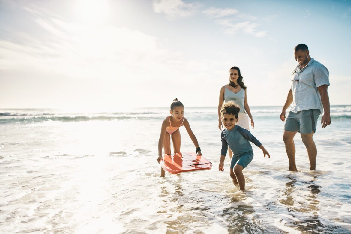 family with children playing on beach